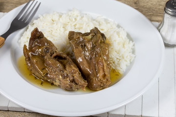 morceaux de coq cuisiné à la bière et riz dans une assiette