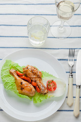 Fried chicken legs in caramelized sauce on a white plate with garnish of vegetables. Mexican, Chinese authentic cuisine. Organic products. View from above. Authentic cuisine.