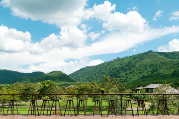 Wooden table and mountain landscape scenic of coffee shop.