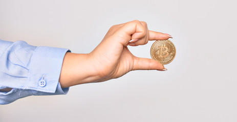 Hand of caucasian young woman holding golden bitcoin money over isolated white background