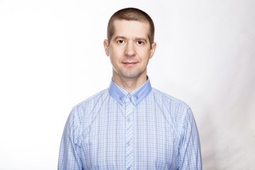 portrait of a confident calm, strict man, in a blue classic shirt; look into the camera. Isolated