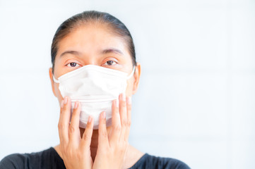 Asian women have to use a face mask to protect against dust pollution and prevent infection from viruses that spread in the air
