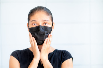 Asian women have to use a face mask to protect against dust pollution and prevent infection from viruses that spread in the air