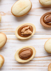Homemade Russian nuts with condensed milk and mascarpone on a light blue background, wafer napkin. Cut nuts with condensed milk. Bitten goodies for tea. Condensed Nuts