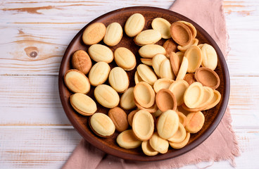 Homemade Russian nuts with condensed milk and mascarpone on a light blue background, wafer napkin. Cut nuts with condensed milk.