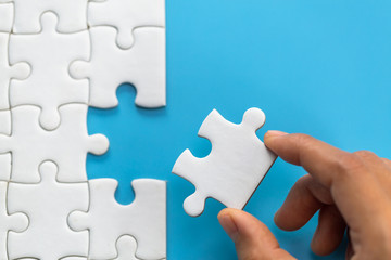 Jigsaw connection between white  jigsaw puzzles, Jigsaw puzzle in the hand of a businessman, ...