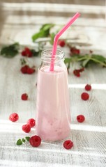 Raspberry milk shake. Milkshake with raspberries in a bottle with a tube. A milky raspberry cocktail. Milk and raspberries are blended with a blender.