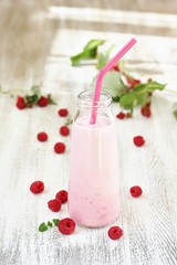 Raspberry milk shake. Milkshake with raspberries in a bottle with a tube. A milky raspberry cocktail. Milk and raspberries are blended with a blender.