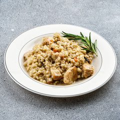 Barley porridge with meat on white plate.