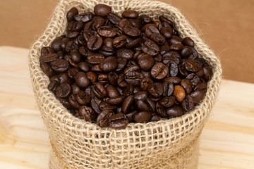 Close up of roasted coffee beans in rustic cloth bag