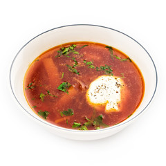 Beetroot soup - Traditional Ukrainian or Russian borscht with sour cream in a white bowl.