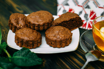 Fototapeta na wymiar homemade cakes, chocolate muffins with mint and tea with lemon