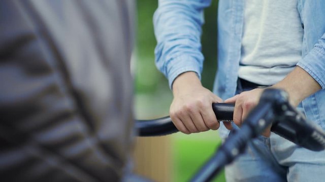 Close up of father gives a nipple to a child who lies in a stroller outdoors