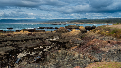 Fototapeta na wymiar Rocky shore in Mendocino County against partly cloudy skies, Laguna Point State park, a tourist attraction in Northern California 