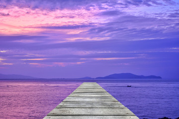 Fototapeta na wymiar Sunset at sea and old wooden bridgeมPerspective view of wooden pier on the sea at sunset with perfectly specular reflection,wooden retro deck and sunrise or sunset sky/ Summer holidays background.