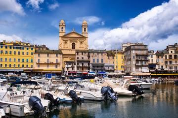 vieuw on église Saint Jean-Baptiste in Bastia from the vieux port with some boats resting in the...