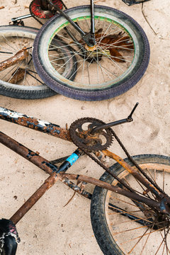 Rusty childen bike in decay in the sand of the beach in Santa Fe village in Siargao Island, Philippines