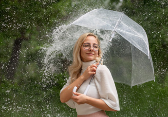 Young girl with umbrella in the pouring rain