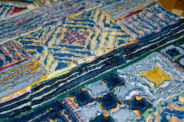 Chenille patterns on a rug made from jeans and fabric.