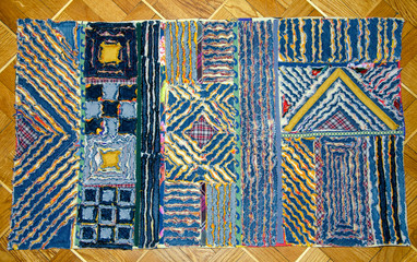 Chenille patterns on a rug made from jeans and fabric.