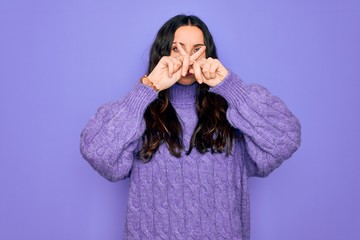 Young beautiful woman wearing casual turtleneck sweater standing over purple background Rejection expression crossing fingers doing negative sign