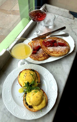 Delicious brunch at the restaurant with aggs Benedict, pancakes and cocktails