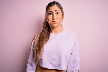 Fototapeta premium Young beautiful sport woman wearing sweatshirt over pink isolated background puffing cheeks with funny face. Mouth inflated with air, crazy expression.