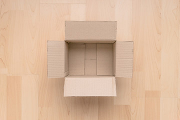 Empty open rectangular cardboard box on wood background. Shopping online object background.