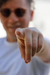 Man with curly hair and sunglasses pointing
