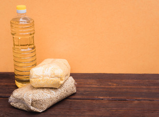 Raw porridge in a package and a bottle of sunflower oil. Stocks of cereals in the package.