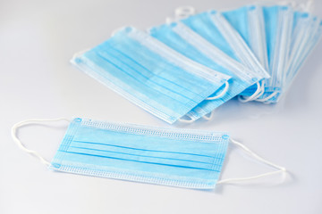 A stack of new unused disposable face masks lying on white background. Seen in Germany in May...