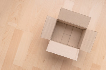 Empty open rectangular cardboard box on wood background. Shopping online object background.