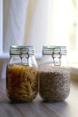 Jars with pasta and oats. Kitchen or pantry interior. Selective focus.