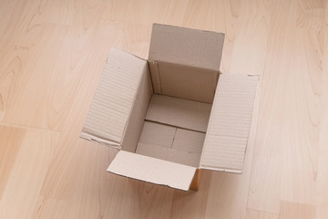 Empty open rectangular cardboard box on wood background. Shopping online object background.