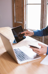 Closeup on male hands using laptop keyboard. Businessman working remotely from home or coworking place