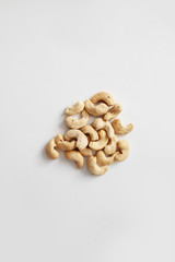 A pile of cashew nuts on a gray background, top view