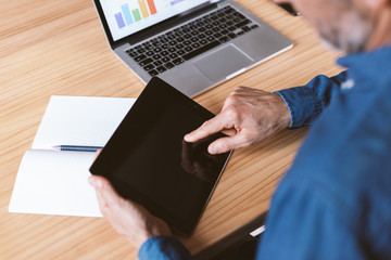 Male hand pointing at tablet screen. Businessman working remotely from home or coworking place.
