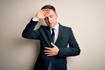 Young handsome business man wearing elegant suit and tie over isolated background Touching forehead for illness and fever, flu and cold, virus sick