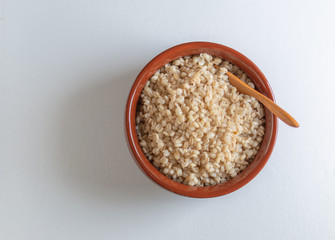 National Russian pearl barley porridge in a ceramic bowl on a white background