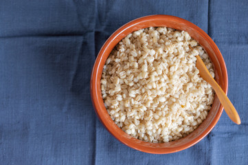 National Russian pearl barley porridge in a ceramic bowl on a blue napkin