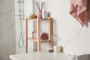 Shelving unit with clean towel in bathroom interior