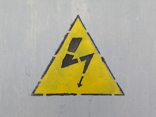 High voltage symbol painted on a gray wall.