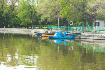 Fototapeta na wymiar Lake view in public park with pedal boats docked