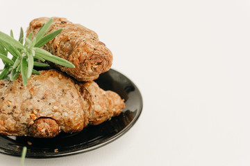 Cozy wheat croissants with sesame seeds in a dark plate isolated on white. Organic food concept.
