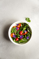 fresh summer salad of spinach, strawberries, onions and balsamic vinegar and edible flowers; 
