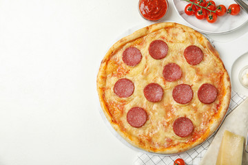 Flat lay composition with tasty pepperoni pizza on white table. Space for text