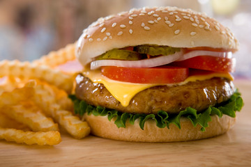 Hamburger with french fries on wooden board.