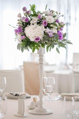 Wedding table decorated on mauve color. Centerpiece full of violet flowers in the middle
