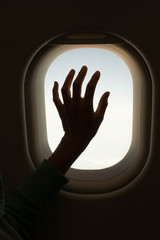 Hand touching an airplane window