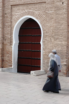 Couple walking in front of Marrakech Koutoubia Mosque